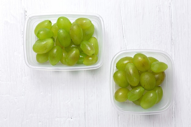 Uvas sazonais frescas em recipientes de plástico prontos para comer