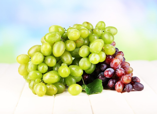 Foto uvas verdes e roxas maduras na mesa de madeira sobre fundo natural