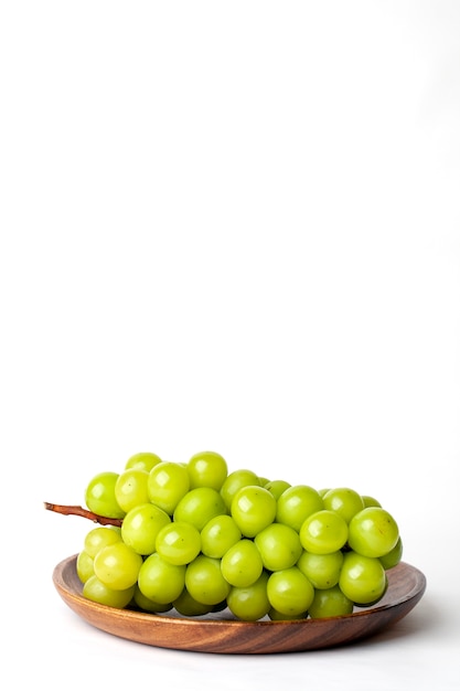 Uvas verdes em um prato de madeira