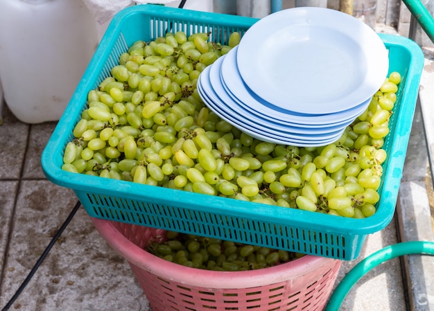 Uvas verdes frescas en la bandeja de plástico.