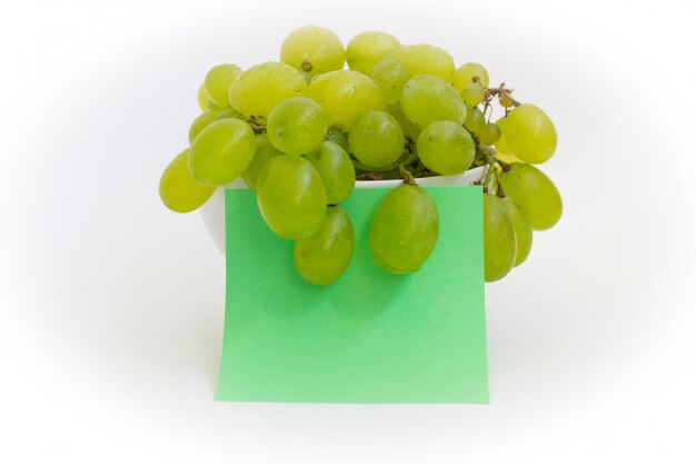 uvas verdes en un plato sobre un fondo blanco