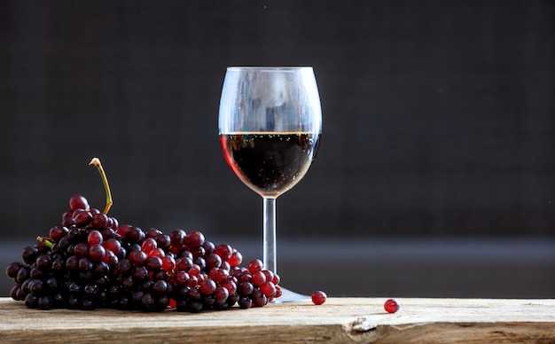 Uvas vermelhas e uma taça de vinho