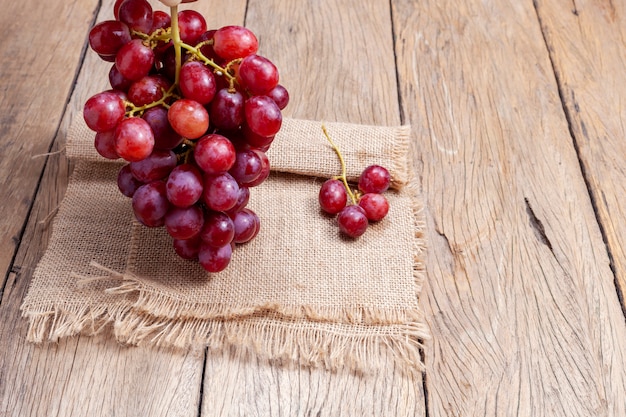 Uvas vermelhas em fundo de mesa de madeira velha