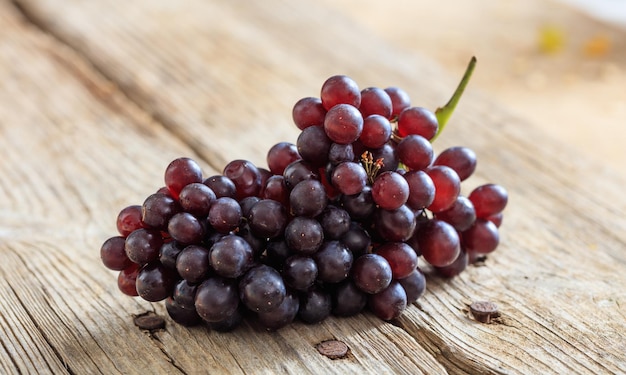 Uvas vermelhas em uma mesa de madeira