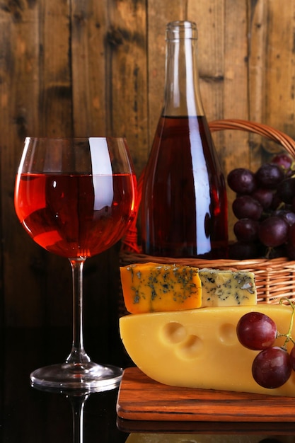 Uvas de vino rosado y queso sobre fondo de madera