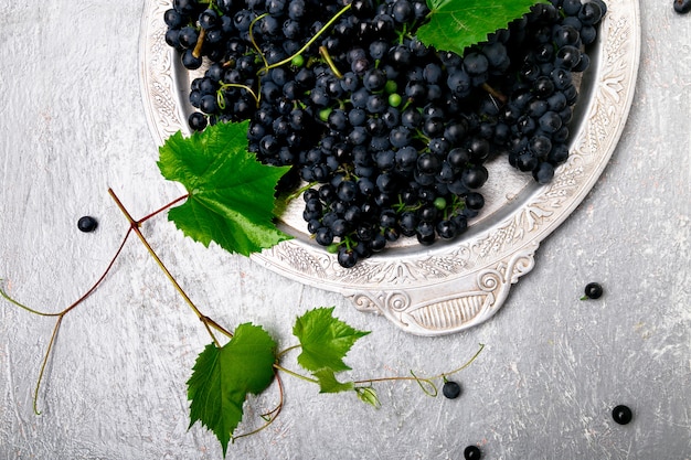 Uvas de vino tinto en bandeja de plata.