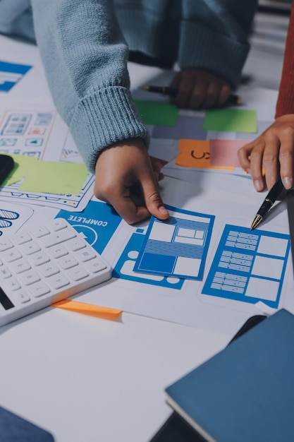 UX UI designer testing prototype on a phone discussing and brainstorming on wireframes for a website and mobile app prototype in the concept of website and mobile application design concept