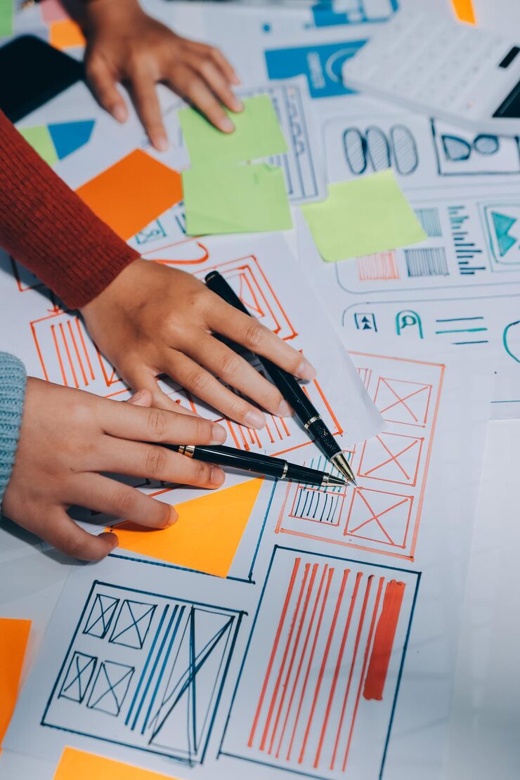 Foto ux ui designer testing prototype on a phone discussing and brainstorming on wireframes for a website and mobile app prototype in the concept of website and mobile application design concept