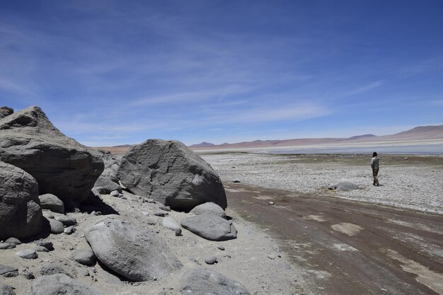 Uyuni Bolívia 10 de fevereiro de 2017 Um turista passa perto das pedras Excursão Offroad no salar de Uyuni