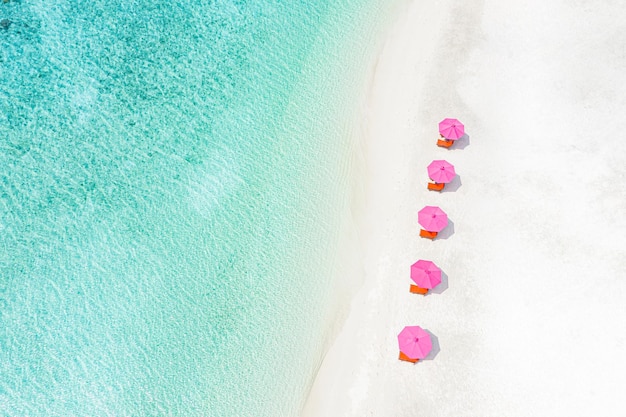 Vacaciones aéreas de lujo en la playa, antecedentes de vacaciones de viajes de verano. Tumbonas, sillas con sombrilla rosa.