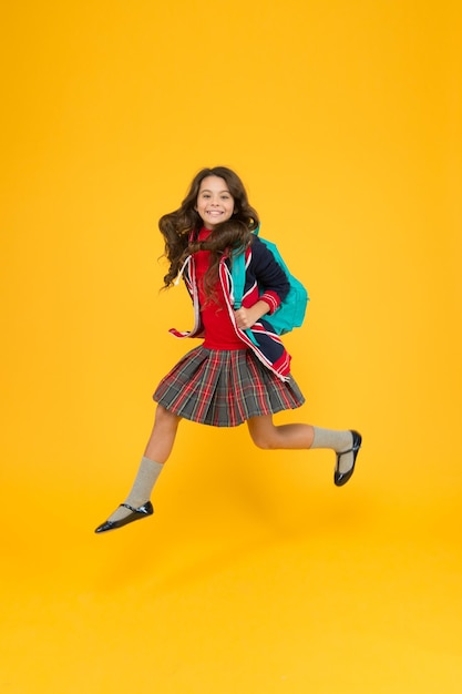 Vacaciones de alegría real en gran bretaña concepto de viaje niña pequeña uniforme sostenga mochila niño gratis con bandera inglesa en la chaqueta vaya a estudiar a inglaterra aprendiendo idiomas escuela británica en inglaterra