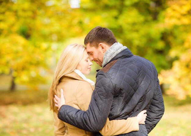 vacaciones, amor, viajes, turismo, relación y concepto de citas - pareja romántica besándose en el parque de otoño