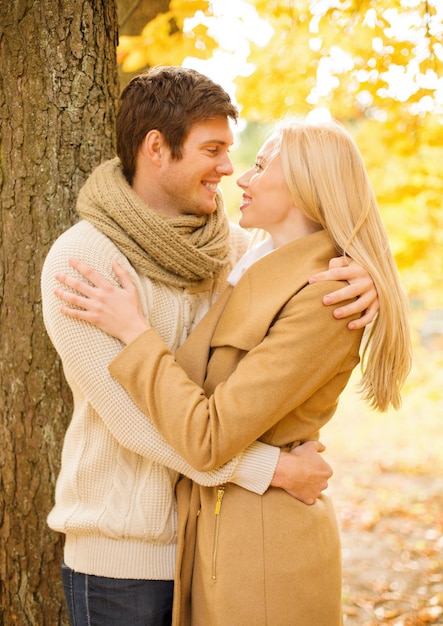 vacaciones, amor, viajes, turismo, relación y concepto de citas - pareja romántica besándose en el parque de otoño