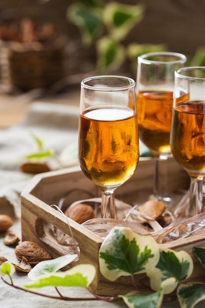 Vacaciones, bebida alcohólica, bebida, concepto digestivo. licor de almendras italiano amaretto sobre una mesa de madera
