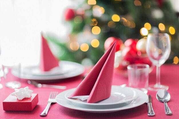 vacaciones, celebración y concepto de hogar - cierre de la habitación con árbol de navidad y mesa decorada