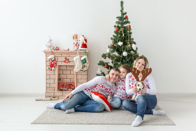 Vacaciones y concepto festivo - Retrato de familia feliz por árbol de Navidad.