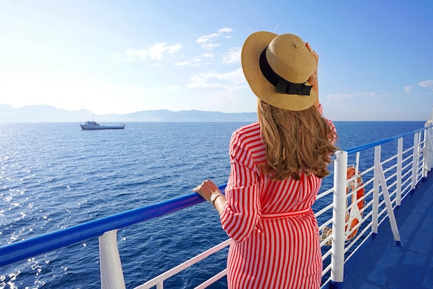 Vacaciones en cruceros Vista posterior de una mujer de moda relajada disfrutando de un viaje en un crucero
