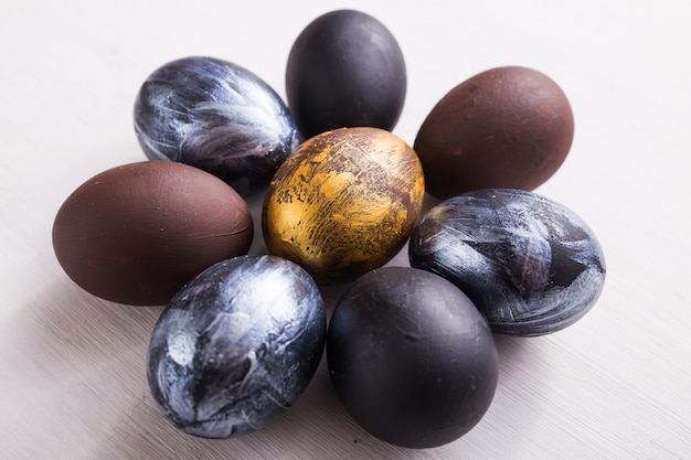 Vacaciones, diseño y concepto moderno de pascua: los huevos de pascua negros y marrones son minimalistas