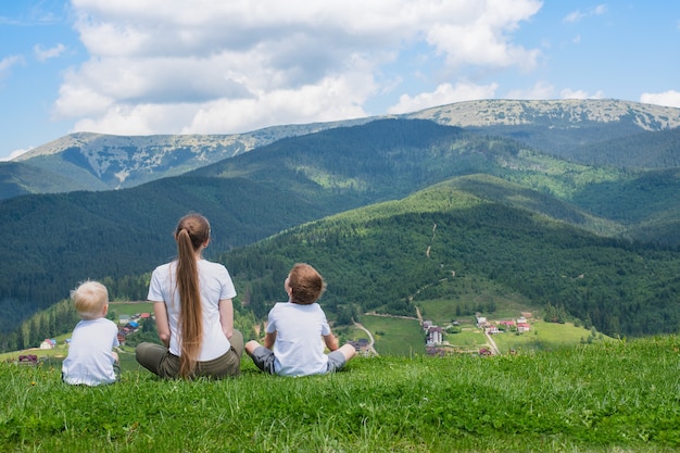 Vacaciones familiares. Madre y dos hijos admiran la vista de la montaña.