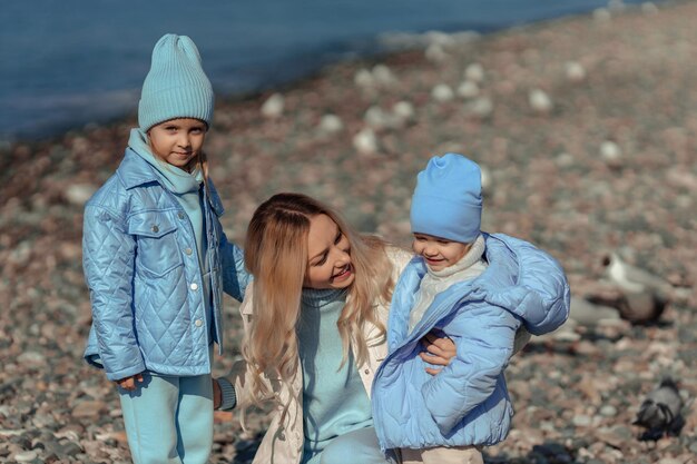 Vacaciones familiares en el mar fuera de temporada feliz madre e hijos caminando por la orilla del mar