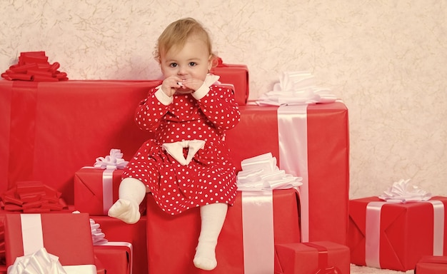 Vacaciones familiares Regalos de Navidad para niños pequeños Regalos para la primera Navidad del niño Celebre la primera Navidad El evento de la primera Navidad del bebé una vez en la vida La niña pequeña juega cerca de la pila de cajas de regalo