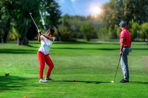 Vacaciones de golf para parejas jugando al golf en un hermoso clima soleado