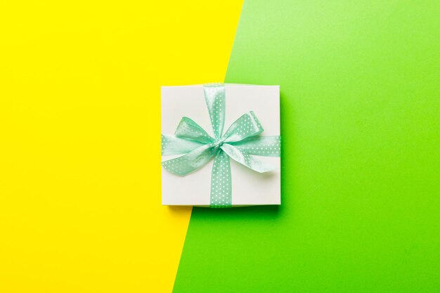 Vacaciones hechas a mano regalo blanco atado cinta verde arco vista superior con espacio de copia Fondo plano de vacaciones Lay cumpleaños o regalo de Navidad Concepto de caja de regalo de Navidad con espacio de copia