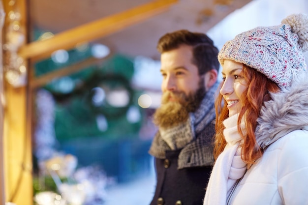 vacaciones, invierno, navidad y concepto de la gente - pareja feliz en ropa de abrigo al aire libre