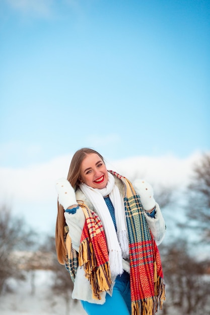 En las vacaciones de invierno, una niña camina con ropa abrigada y disfruta de la vida. Una sonrisa es buena. Trabajo de un dentista.