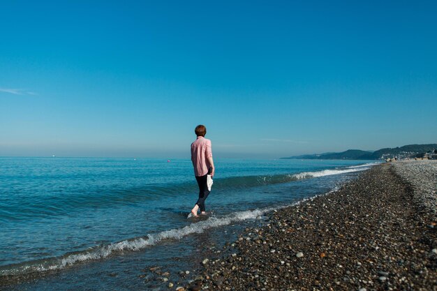 Vacaciones en el mar. Una cgirl camina por la playa.