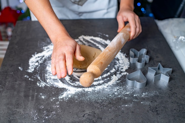 Vacaciones de Navidad y año nuevo, mamá e hijos preparan galletas de jengibre.