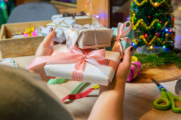 Vacaciones de Navidad y concepto de personas: manos de mujeres preparando regalos de Navidad