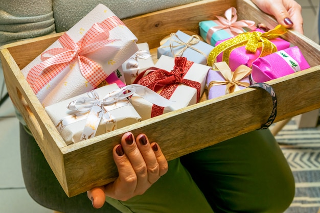 Vacaciones de Navidad y concepto de personas: manos de mujeres preparando regalos de Navidad