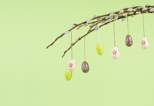 Vacaciones de Pascua, pequeños huevos de colores colgando de ramas de sauce, tarjeta de felicitación, temporada de primavera