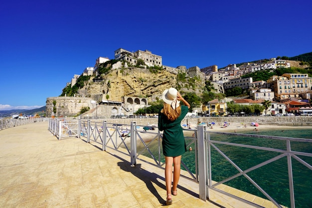 Vacaciones en Pizzo Calabro Italia Vista posterior de la hermosa chica de moda disfrutando de la vista de la fortaleza de Pizzo Calabria Vacaciones de verano en Italia