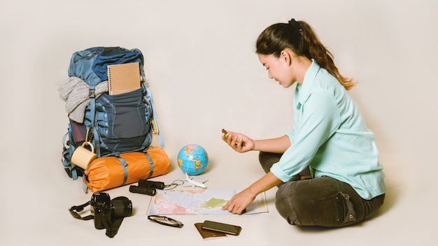 Foto vacaciones de planificación turística con la ayuda del mapa del mundo con otros accesorios de viaje alrededor.