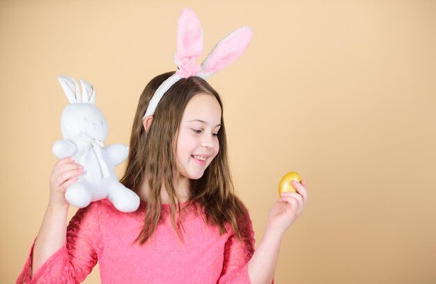 Vacaciones de primavera Niña sosteniendo huevo de Pascua y conejito Niño lindo con conejo de Pascua trayendo huevo en primavera Niño pequeño con huevo de color y liebre Temporada de primavera Celebrando el equinoccio de primavera