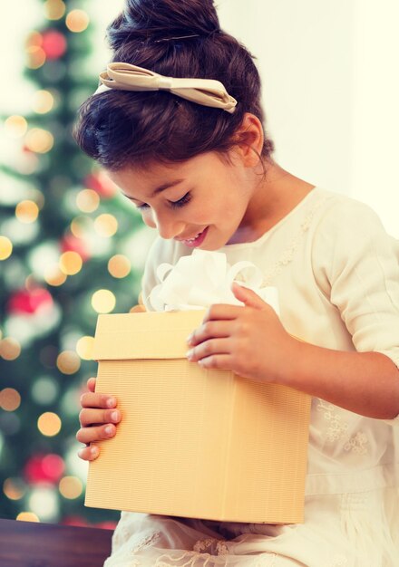 vacaciones, regalos, navidad, concepto de Navidad - niña feliz con caja de regalo