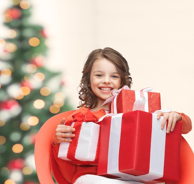 vacaciones, regalos, navidad, concepto de Navidad - niña feliz con cajas de regalo