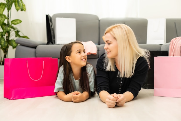 vacaciones, regalos, navidad, navidad, concepto de cumpleaños - feliz madre e hija niña con bolsas de regalo