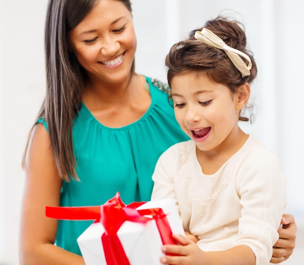 vacaciones, regalos, navidad, navidad, concepto de cumpleaños - feliz madre e hija niña con caja de regalo