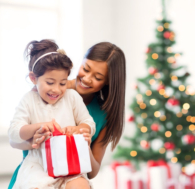 vacaciones, regalos, navidad, navidad, concepto de cumpleaños - feliz madre e hija niña con caja de regalo