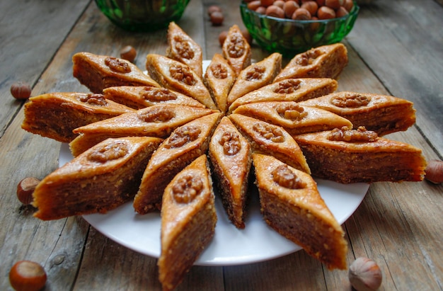 Foto vacaciones tradicionales de azerbaiyán galletas baklava en plato blanco en el rústico con nueces