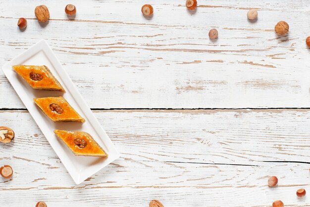 Vacaciones tradicionales de Azerbaiyán Novruz cookies baklava en plato blanco sobre el fondo blanco con nueces y shakarbura