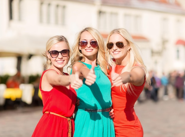 vacaciones y turismo, amigos, despedida de soltera, concepto de chicas rubias: tres hermosas mujeres en la ciudad mostrando los pulgares para arriba