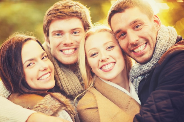 vacaciones, vacaciones, concepto de gente feliz - grupo de amigos o parejas divirtiéndose en el parque de otoño