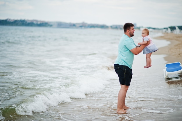 Vacaciones de verano. Actividad al aire libre de padres y personas con niños. Felices vacaciones en familia. Padre con hija en la playa de arena de mar.