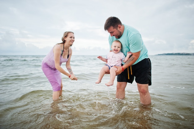 Foto vacaciones de verano. actividad al aire libre de padres y personas con niños. felices vacaciones en familia. padre, madre embarazada, hija en la playa de arena de mar.