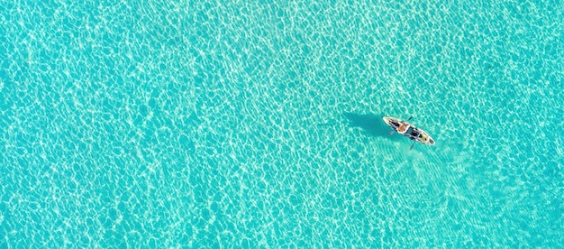 Foto vacaciones de verano actividades deportivas divertidas hombres en kayak en canoa en azul turquesa mar egeo vista aérea