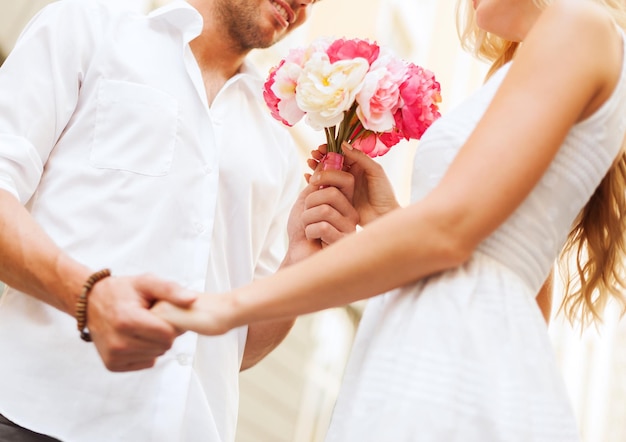 vacaciones de verano, amor, relación y concepto de citas - pareja con ramo de flores en la ciudad